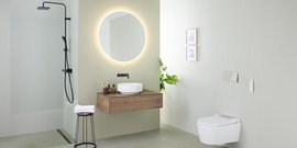 Ein modernes Badezimmer mit einer eleganten Dusche, einem runden Spiegel und einer stilvollen Holzwaschbeckenablage.