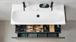 Ein elegantes Badezimmer mit einer weißen Badewanne und einem modernen Waschbecken, das stilvoll dekoriert ist.