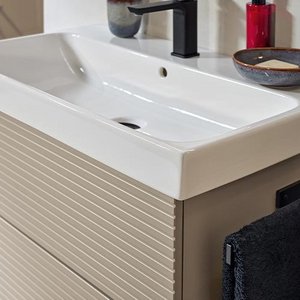 Ein modernes Waschbecken mit einem eleganten Wasserhahn, umgeben von einem stilvollen Badezimmerdesign.