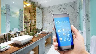 Ein modernes Badezimmer mit eleganten Waschbecken und einem Smartphone, das eine smarte Steuerung zeigt.