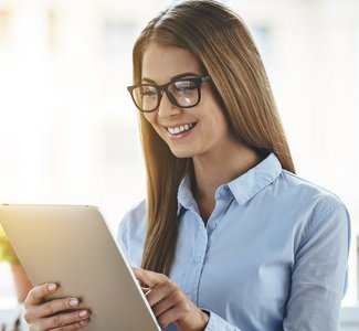 Eine Buerofrau die ein Tablet bedient