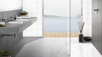 Ein modernes Badezimmer mit einem eleganten Waschbecken aus Beton und Blick auf einen ruhigen See durch große Fenster.